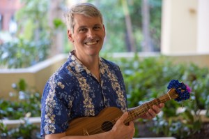 Eric holding his ukulele and wearing an aloha shirt in Waikiki